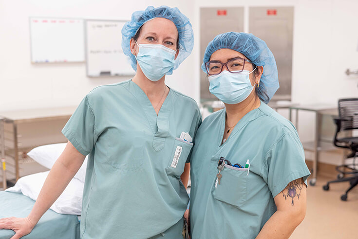 Two women stand in an operating theatre. 